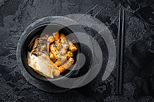 Korean street food Tteokbokki, Topokki fried rice cake stick in spicy sauce. Black background. Top view