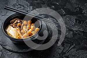 Korean street food Tteokbokki, Topokki fried rice cake stick in spicy sauce. Black background. Top view. Copy space