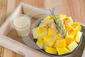 Korean style fresh mango shaved ice on wood table .