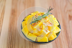 Korean style fresh mango shaved ice on wood table .