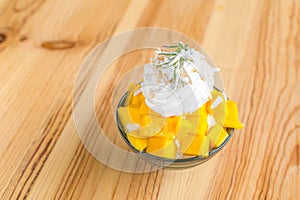 Korean style fresh mango shaved ice on wood table .