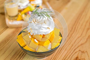 Korean style fresh mango shaved ice on wood table .