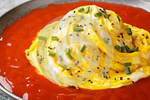 Korean swirl omelette tornado on top of fried rice and hot sauce close-up in a plate. Horizontal