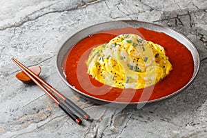 Korean Tornado Egg Omelette with Fried Rice and Sriracha Ketchup closeup on the plate. Horizontal