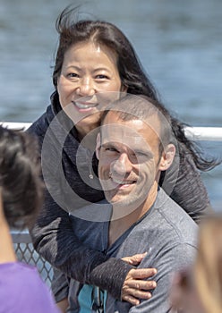 Korean wife enjoying a vacation boat tour with her caucasian husband in Seattle, Washington