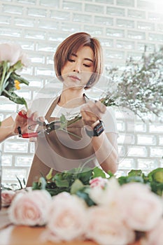 Korean woman Florist cutting bouquet of flowers