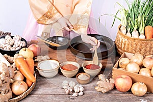 Korean woman is wearing a traditional hanbok, she making Kimchi