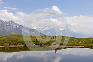 Koruldi Lake -  A female hiker at a lake with view on mountains in Upper Svaneti, Caucasus, Georgia.