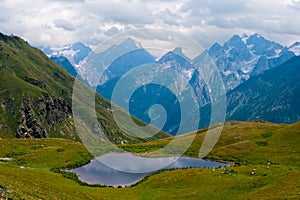 Koruldi lakes in Caucasus mountains, Mestia, Svaneti region, Georgia. Summer day, green hills, high mountain pasture for livestock