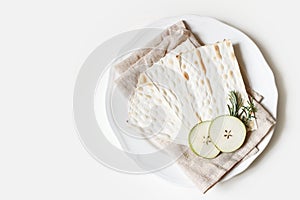 Kosher food concept. Seder dinner composition. Matzo bread, egg, apple fruit and herbs on porcelain plate and linen