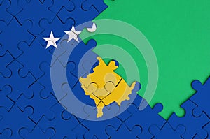 Kosovo flag is depicted on a completed jigsaw puzzle with free green copy space on the right side