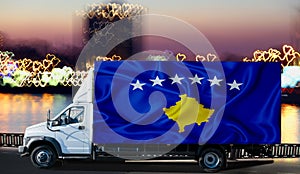 Kosovo flag on the side of a white van against the backdrop of a blurred city and river. Logistics concept