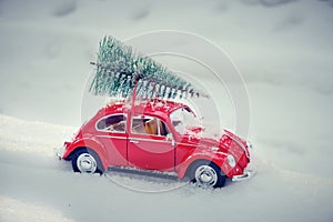 Kostanay, Kazakhstan 2022.Red Volkswagen beetle with spruce on roof, against background white snow