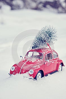 Kostanay, Kazakhstan 2022.Red Volkswagen beetle with spruce on roof, against background white snow