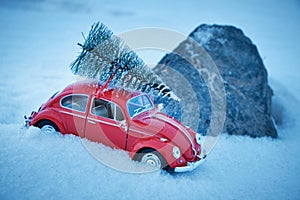 Kostanay, Kazakhstan 2022.Red Volkswagen beetle with spruce on roof stuck in snow