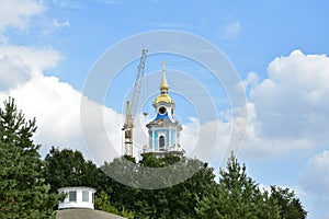 The Kostroma Kremlin is under construction. A construction crane is erecting a bell tower. Blue sky