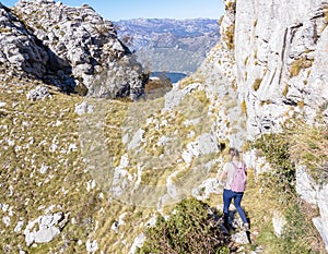 Kotor - Woman with backpack on idyllic via ferrata hiking trail from Kotor to Derinski Vrh, Montenegro