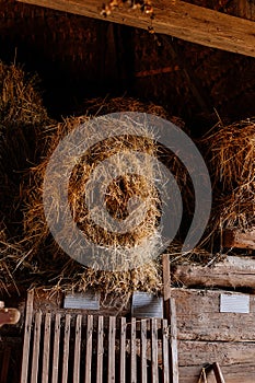 Kourim, Czech Republic, 17 December 2023: Inside rustic wooden old barn hay, Attic of hayloft, Bales dry straw, light beams farm,