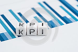 KPI, Key Performance Indicator concept, small cube block with alphabets building the word KPI on yearly chart and graph reports