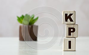 KPI word on wooden cubes on a light background with a cactus