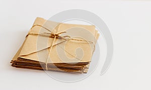 Kraft envelopes lie on a light background tied with twine.