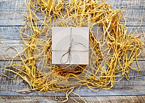 Kraft gift box on wooden table with raffia or twine