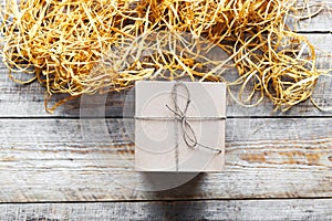 Kraft gift box on wooden table with raffia or twine