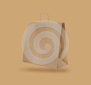 Kraft paper bag on beige background. Mockup for design