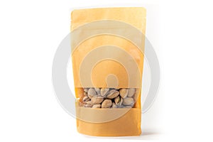 Kraft paper doypack pouch flexible packaging with window zipper on white background filled with pistachios