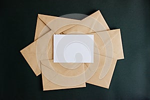 Kraft paper envelope with white card on black background.