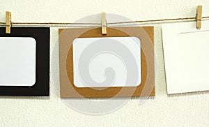 Kraft paper frame hanging on lacing on white wall background with space. There is empty space in the frame for text.