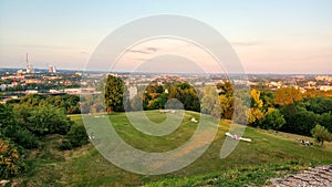 Krakow cityscape, Poland. View from afar, beautiful sammer sunset with people on the rest