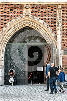 Beggar in front open doors in church