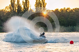 Jet ski racer drives watercraft splashing in sunset while racing at South Russian Aquabike
