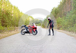 KRASNOYARSK, RUSSIA - April 27, 2018: Beautiful motorcyclist in full gear and helmet on a red and black Honda 2005 CBR 600 RR