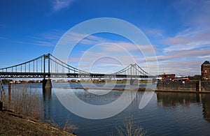 View on old inland harbor with steel bridge over river rhine, industrial area background