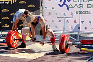 Young boy does an exercise with a barbell