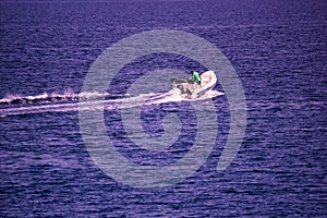 Kreta or Crete  Greece -: A man riding on a jet motor boat. waves are formed by speed through water by jet ski