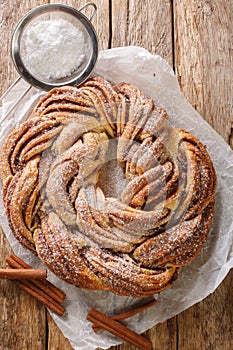 Kringle Delicious Brioche with sugar and cinnamon closeup on the paper. Vertical top view