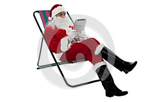 Kris Kringle relaxing and using electronic tablet