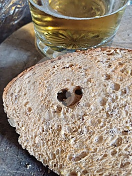 Krusty bread with a hard shape and a pint of lager in the background