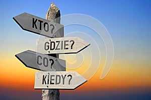 Kto? Gdzie? Co? Kiedy? Polish/ Who? Where? How? When? English - wooden signpost, sunset sky