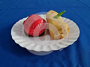 Ku cake and rissoles in a white container on a blue cloth background