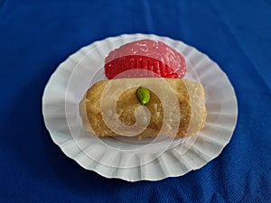 Ku cake and rissoles in a white container on a blue cloth background