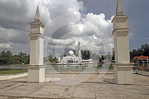 The Kuala Ibai Floating Mosque or Tengku Tengah Zaharah Mosque under heavy clouds as seen from lakeside pavilion in Terengganu, M photo