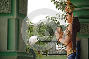 KUALA LUMPUR, MALAYSIA - AUGUST 23, 2013: Statue of Hindu deity in praying posture in the temple of Batu Caves.