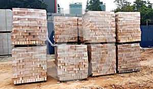 Stock pile of clay brick on wooden pallets stacked at the construction site.