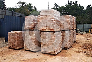 Stock pile of clay brick on wooden pallets stacked at the construction site.