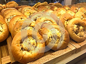 Various types of breads are displayed for sale inside the bakery display rack.