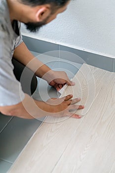 Kuala Lumpur, Malaysia - March 1, 2020: A man installing new vinyl tile floor, a DIY home project